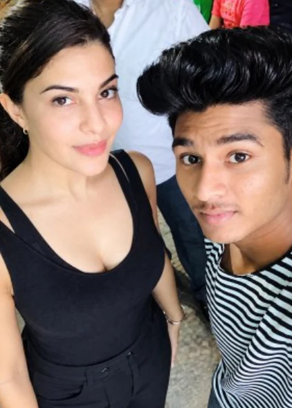 Two artists posing for a selfie at an event.