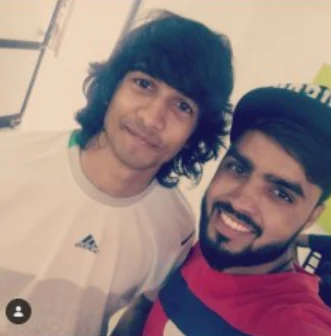Two artists taking a selfie together backstage.