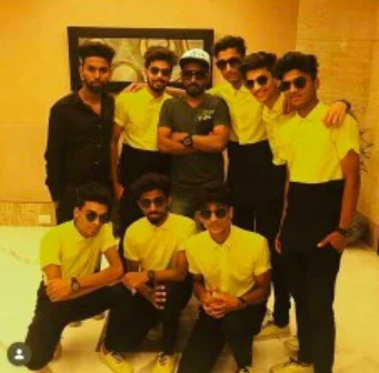 The crew gathering for a group photo in matching yellow shirts.