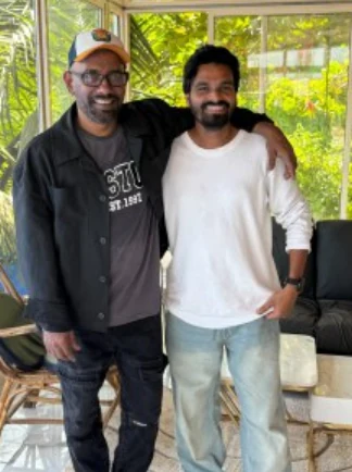 Two creative collaborators smiling together outside a venue.