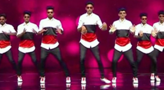 Crew standing side by side in matching red, white, and black outfits.