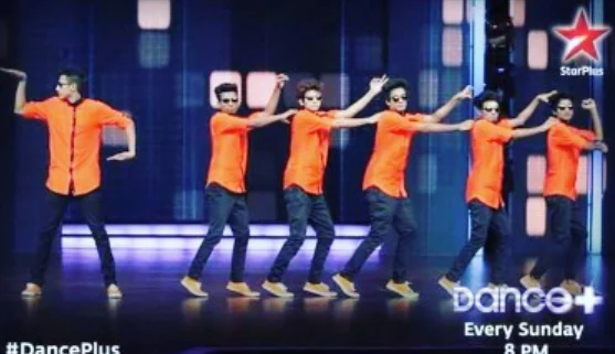 Dancers in orange shirts performing a synchronized routine on Dance Plus.