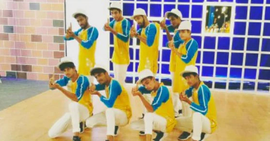 The crew striking a group pose in yellow and blue outfits.